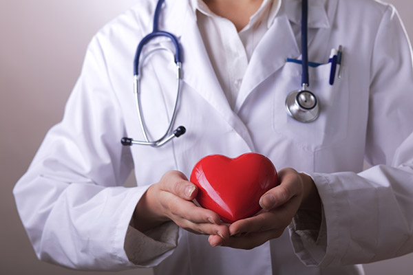 doctor with stethoscope holding heart,on dark background